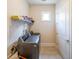 Functional laundry room with modern washer and dryer units and storage shelving at 307 Serenity Way, Woodstock, GA 30188