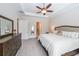 Bright main bedroom with a large bed, soft lighting, and a wooden dresser at 307 Serenity Way, Woodstock, GA 30188