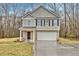 Charming two-story home featuring a brick and siding facade, front porch, and attached garage at 370 Cassidy Trl, Douglasville, GA 30134