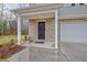 Home's front entrance with a brick facade, white support columns, and a dark-stained front door at 370 Cassidy Trl, Douglasville, GA 30134