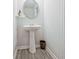 Stylish powder room featuring a pedestal sink, round mirror, and neutral decor at 370 Cassidy Trl, Douglasville, GA 30134