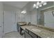 Bathroom featuring double sinks, granite countertops, large mirrors, and a tiled shower at 5719 Sierra Bend Way, Hoschton, GA 30548