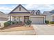 Charming single-Gathering home boasts a manicured front yard, inviting entrance, and attached two-car garage at 5719 Sierra Bend Way, Hoschton, GA 30548