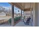 Cozy covered front porch with decorative columns, a comfortable glider, and serene neighborhood views at 5719 Sierra Bend Way, Hoschton, GA 30548