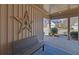 Inviting covered front porch with an exterior star decoration, bench, and blue outdoor rug at 5719 Sierra Bend Way, Hoschton, GA 30548