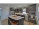 Modern kitchen features stainless steel appliances, dark cabinetry, and a spacious center island with seating at 5719 Sierra Bend Way, Hoschton, GA 30548