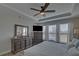 Bedroom with tray ceiling, dark wood furniture, a flat screen tv, and large windows at 5719 Sierra Bend Way, Hoschton, GA 30548