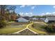 Expansive backyard featuring a walking path, lush grass, fire pit, and beautiful landscaping at 213 Saratoga Dr, Acworth, GA 30102