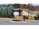 Community entrance with stone-based Artisan at Victory sign, black fencing, and lush evergreens at 213 Saratoga Dr, Acworth, GA 30102