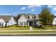 Inviting home featuring gray siding, dormer windows, a cozy front porch, and professionally landscaped lawn at 213 Saratoga Dr, Acworth, GA 30102