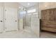 Modern bathroom with a glass-enclosed shower, marble floors, and a wooden storage cabinet at 2975 Thistle Trl, Suwanee, GA 30024