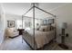 Neutral bedroom featuring a canopy bed, bedside tables and seating area at 3565 Haddon Hall Nw Rd, Atlanta, GA 30327