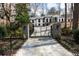 A two-story white home with black trim on windows, stone pillar accents, and an electronic gate at 3565 Haddon Hall Nw Rd, Atlanta, GA 30327