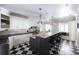 Spacious kitchen with white cabinets, a large island with granite countertops, and black and white tile flooring at 3565 Haddon Hall Nw Rd, Atlanta, GA 30327