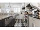 Gourmet kitchen with stainless steel appliances, a farmhouse sink, custom cabinets, and checkered flooring at 3565 Haddon Hall Nw Rd, Atlanta, GA 30327