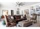 Living room with a cozy leather couch, decorative pillows, ottoman, bookshelves, and a ceiling fan at 3565 Haddon Hall Nw Rd, Atlanta, GA 30327