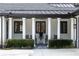 An outdoor porch with slate tile, white columns, black trim on windows, and black outdoor furniture at 3565 Haddon Hall Nw Rd, Atlanta, GA 30327