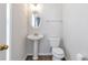 Well-lit half bathroom with a pedestal sink, oval mirror, and wood-look flooring at 4000 Howell Park Rd, Duluth, GA 30096