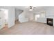 Spacious living room featuring plush carpeting, a cozy fireplace, and a ceiling fan at 4000 Howell Park Rd, Duluth, GA 30096