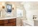 Bathroom featuring marble tiling, a modern vanity, a soaking tub, and a large window at 57 Rumson Ne Way, Atlanta, GA 30305