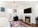 Bright bedroom featuring a fireplace, television, light gray walls, and dark hardwood floors at 57 Rumson Ne Way, Atlanta, GA 30305