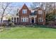 Charming brick home with a well-manicured lawn and mature trees and a screen in porch to the side at 57 Rumson Ne Way, Atlanta, GA 30305