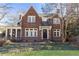 Charming brick home with a well-manicured lawn and mature trees and a screen in porch to the side at 57 Rumson Ne Way, Atlanta, GA 30305