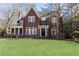 Charming brick home with a well-manicured lawn and mature trees and a screen in porch to the side at 57 Rumson Ne Way, Atlanta, GA 30305