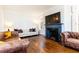 Cozy living room with hardwood floors, a white couch, a leather couch and a fireplace with a TV above at 57 Rumson Ne Way, Atlanta, GA 30305