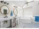 Bright bathroom featuring double sinks, round mirrors, soaking tub, and blue and white color scheme at 724 Laurel Chase Sw, Marietta, GA 30064