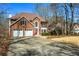 Traditional brick home boasts a well-maintained lawn, two car garage, and mature trees at 724 Laurel Chase Sw, Marietta, GA 30064