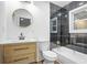 Stylish bathroom with a vanity, toilet, round mirror and tiled shower/tub combination at 1027 Mount Airy Sw Dr, Atlanta, GA 30311