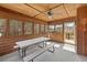 Cozy sunroom with wood paneled walls, ceiling fan, and walls of windows providing a stunning view at 2999 Paul Harris Rd, Dallas, GA 30157