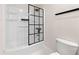 Bright bathroom with tub and shower combo featuring sleek black shower door at 1057 Fortress Sw Ave, Atlanta, GA 30315