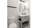 Modern powder room with gray vanity, sleek fixtures, and stylish mirror at 1057 Fortress Sw Ave, Atlanta, GA 30315