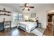 A bedroom with a ceiling fan, desk, dark wood floors, and bright natural light at 2031 Audubon Ne Dr, Atlanta, GA 30329