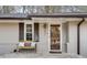 Inviting front porch with a wooden bench, decorative pillows, and a charming front door with sidelight at 2031 Audubon Ne Dr, Atlanta, GA 30329