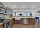 Kitchen features an open view to living area with stainless steel appliances, tile backsplash, and hardwood flooring at 2031 Audubon Ne Dr, Atlanta, GA 30329