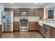 A kitchen featuring stainless steel appliances, a farmhouse sink, and wood cabinets and floors at 2031 Audubon Ne Dr, Atlanta, GA 30329