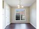 Well-lit dining area featuring hardwood floors, a modern chandelier, and a view through a large window at 3326 Waldrop Trl, Decatur, GA 30034