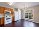 Eat-in kitchen with wooden cabinets, white appliances, and a window offering natural lighting at 3326 Waldrop Trl, Decatur, GA 30034