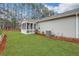 Well-maintained backyard with a green lawn, partial fence, and a view of the house with a screened-in porch at 3893 Shelleydale Dr, Powder Springs, GA 30127