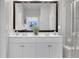 Elegant bathroom featuring double sinks, a large mirror, and a modern glass shower at 3895 Shelleydale Dr, Powder Springs, GA 30127