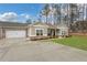 Traditional home boasting a spacious driveway leading to a two-car garage in front of the manicured lawn at 3893 Shelleydale Dr, Powder Springs, GA 30127