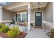 Close-up of a cozy front porch featuring decorative plants, stylish lighting, and a welcoming front door at 3895 Shelleydale Dr, Powder Springs, GA 30127