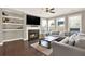 Cozy living room featuring hardwood floors, a fireplace, built-in shelving, and ample natural light, perfect for relaxation at 103 Patrick Way, Marietta, GA 30064