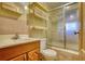 Compact bathroom with a wood vanity, sink, toilet, shelves, and shower-tub combo at 5500 Rockbridge Road, Stone Mountain, GA 30088