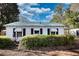 Charming home featuring mature landscaping, dark shutters, and a tin roof at 5500 Rockbridge Road, Stone Mountain, GA 30088