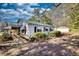 Home exterior featuring a ramp, mature landscaping, and an outbuilding for extra storage at 5500 Rockbridge Road, Stone Mountain, GA 30088