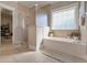 Bright bathroom with tub, walk-in shower, and tile floors at 108 Jasmine Way, Villa Rica, GA 30180